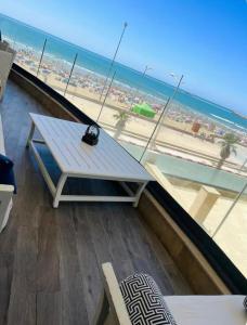 a bench on a balcony with a view of the beach at Mehdia's Paradise in Kenitra +20 photos