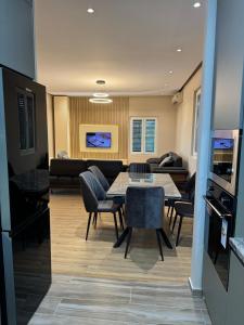 a dining room and living room with a table and chairs at The Lake Villa in Tirana