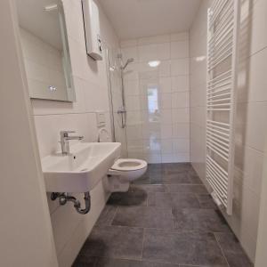 a white bathroom with a sink and a toilet at Heart of Essen in Essen