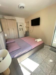 une chambre avec un grand lit et une télévision à écran plat dans l'établissement Thanas Apartment, à Himarë