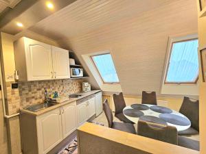 a kitchen with a table and chairs in a room at Apartman Siesta Bük - Bükfürdő in Bük +104 photos