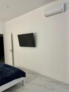 Cette chambre blanche dispose d'une télévision murale. dans l'établissement Затишні апартаменти в серці Аркадії, à Odessa