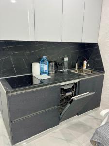 une cuisine avec un évier et un lave-vaisselle dans l'établissement Затишні апартаменти в серці Аркадії, à Odessa