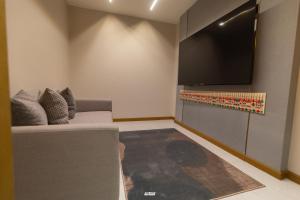 a living room with a couch and a flat screen tv at Golden New Hotel in Abha