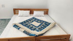 a bed with a blue and white blanket on it at Swagat hotel in Uttarkāshi