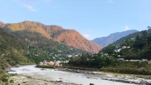 a view of a river with mountains in the background at Swagat hotel in Uttarkāshi
