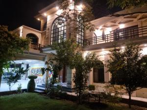 a large white building at night with lights at Elegance Abounds in Qila Malla Singh