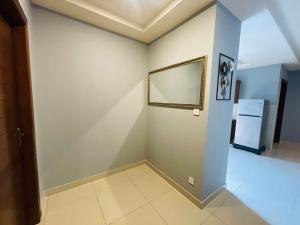 a room with a white wall and a refrigerator at IMAR Services Apartment in Rawalpindi
