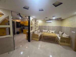 Cette chambre dispose d'un canapé, d'une table et d'une cuisine. dans l'établissement Wassime location, à Taourirt