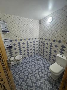 La salle de bains est pourvue de toilettes et de carrelage. dans l'établissement Wassime location, à Taourirt 3 autres photos