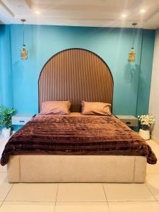a bedroom with a large bed with a large headboard at IMAR Services Apartment in Rawalpindi