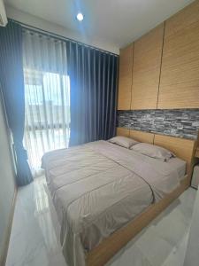 a bedroom with a large bed with blue curtains at The sea forest 101 in Rayong