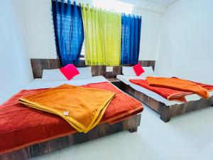 - 2 lits dans une chambre dotée de rideaux colorés dans l'établissement Shree Tekchand Palace, à Ujjain