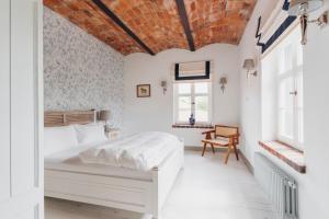 a bedroom with a white bed and a brick ceiling at Oficyna Ciekocinko in Ciekocinko