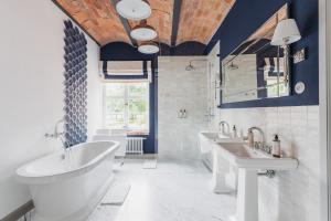 a bathroom with two sinks and a tub at Oficyna Ciekocinko in Ciekocinko