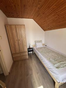 a bedroom with a bed and a wooden ceiling at Peresi paradicsom in Mezőtúr +4 photos