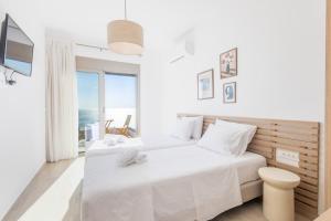 a white bedroom with two beds and a view of the ocean at VILLA PAVA MARE sea view brand new 2025 in Vrachonisída touArchangélou +55 photos