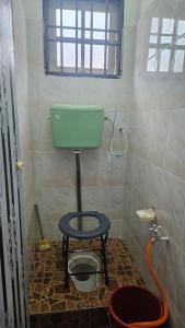 a bathroom with a green toilet and a stool at Rumah Inap Haziq in Seri Manjung