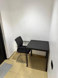 un escritorio negro y una silla en una habitación en Ogunade Stores Apartment, en Iponri
