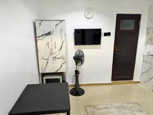 sala de estar con mesa negra y TV en Ogunade Stores Apartment, en Iponri