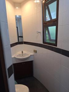 a bathroom with a sink and a toilet and a window at Mango Paradise, in der Nähe des Black Mountain Golf Clubs in Hua Hin