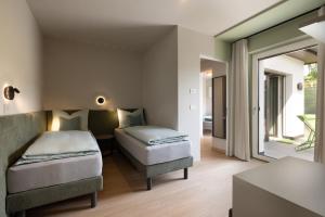 a bedroom with two beds and a window at Villa Sawian in Appiano sulla Strada del Vino