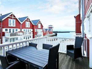 a balcony with a wooden table and chairs and a lighthouse at Seaside Escape in Bagenkop - By Traum Ferienwohnungen in Bagenkop +23 photos