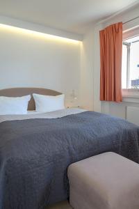 a bedroom with a bed with a blue blanket and a window at Coastline _Nor31 _ 2_ in Westerland (Sylt)
