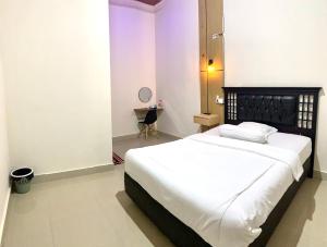 a bedroom with a large bed with white sheets at Riltree hotel in Bulukumba +20 photos