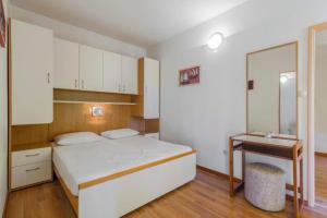 a bedroom with a bed and a desk in it at Apartments Konta Vodice in Vodice