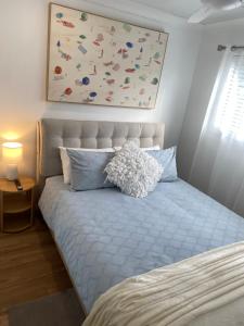 a bedroom with a bed with a painting above it at The Lazy Roo accommodation in Moonee Beach