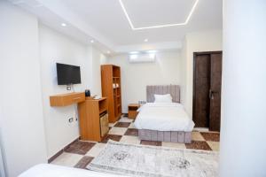 a bedroom with a bed and a tv on a wall at Imperial Pyramids View Inn in Cairo