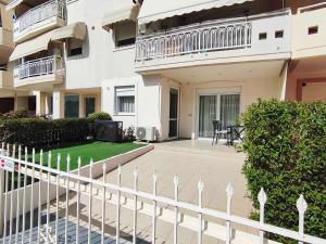 a white fence in front of a building at PERLA apartment in Alexandroupoli