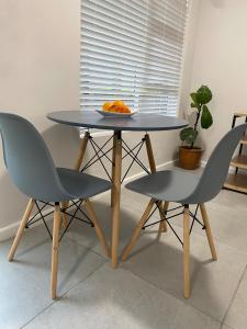 a table with two chairs and a plate of oranges at Garden flat Durbanville - with Office, WiFi and secure gated parking in Eversdal