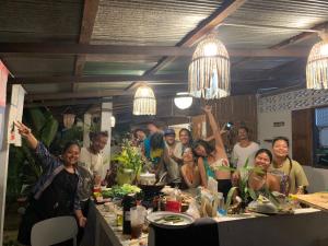 a group of people posing for a picture at a table at Ka Prao Kai Hostel in Pai