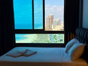 a bed in a room with a large window at Carmel Holiday Apartments in Netanya +291 photos