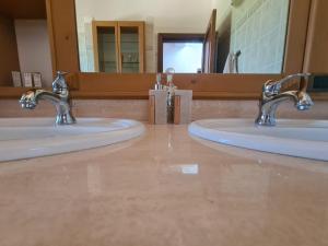 two sinks in a bathroom with two faucets at Residenza Magister in Serramonacesca