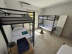 Windmill Hostel في سانت جوليانز: غرفة بها سريران بطابقين وطاولة