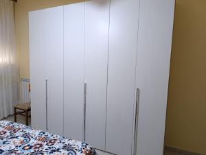 a bedroom with white cabinets next to a bed at La Fenice in Mola di Bari +12 photos