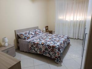 a bedroom with a bed with a floral comforter at La Fenice in Mola di Bari