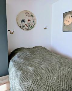 a bedroom with a bed and a plate on the wall at Appartement ZEN - 5 minutes du centre, parking gratuit in Nancy