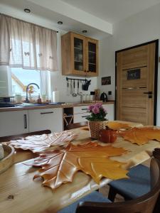 a kitchen with a wooden table with leaves on it at MICHAŁÓWKA - Domek w Górach przy Lesie - Energylandia in Targanice