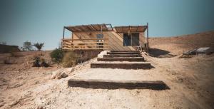 a wooden house in the middle of a desert at Amara Escape in Zuqim