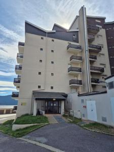 un grande edificio bianco con parcheggio di Studio cabine Les Angles - Soleil et Montagne a Les Angles Altre 2 foto