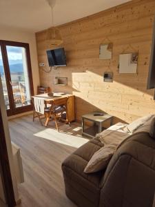 un soggiorno con divano e parete in legno di Studio cabine Les Angles - Soleil et Montagne a Les Angles