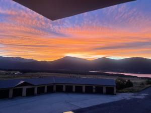 a sunset over a building with mountains in the background at Studio cabine Les Angles - Soleil et Montagne in Les Angles