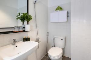 a white bathroom with a toilet and a sink at Hoang Phi Saigon Hotel & Spa in Ho Chi Minh City