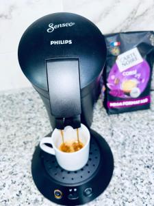 a coffee maker is making a cup of coffee at Dar Najat - Proche Aéroport - Stade - Gare routière in Tangier +14 photos
