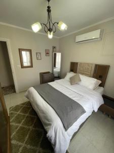a bedroom with a large white bed in it at Modern Comforts Await! Spacious 2BR 2Bath w Free WiFi Stylish Furniture in Madinaty