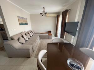 a living room with a couch and a flat screen tv at Modern Comforts Await! Spacious 2BR 2Bath w Free WiFi Stylish Furniture in Madinaty